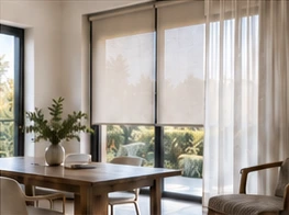 Cortina roller junto a una cortina textil en un comedor